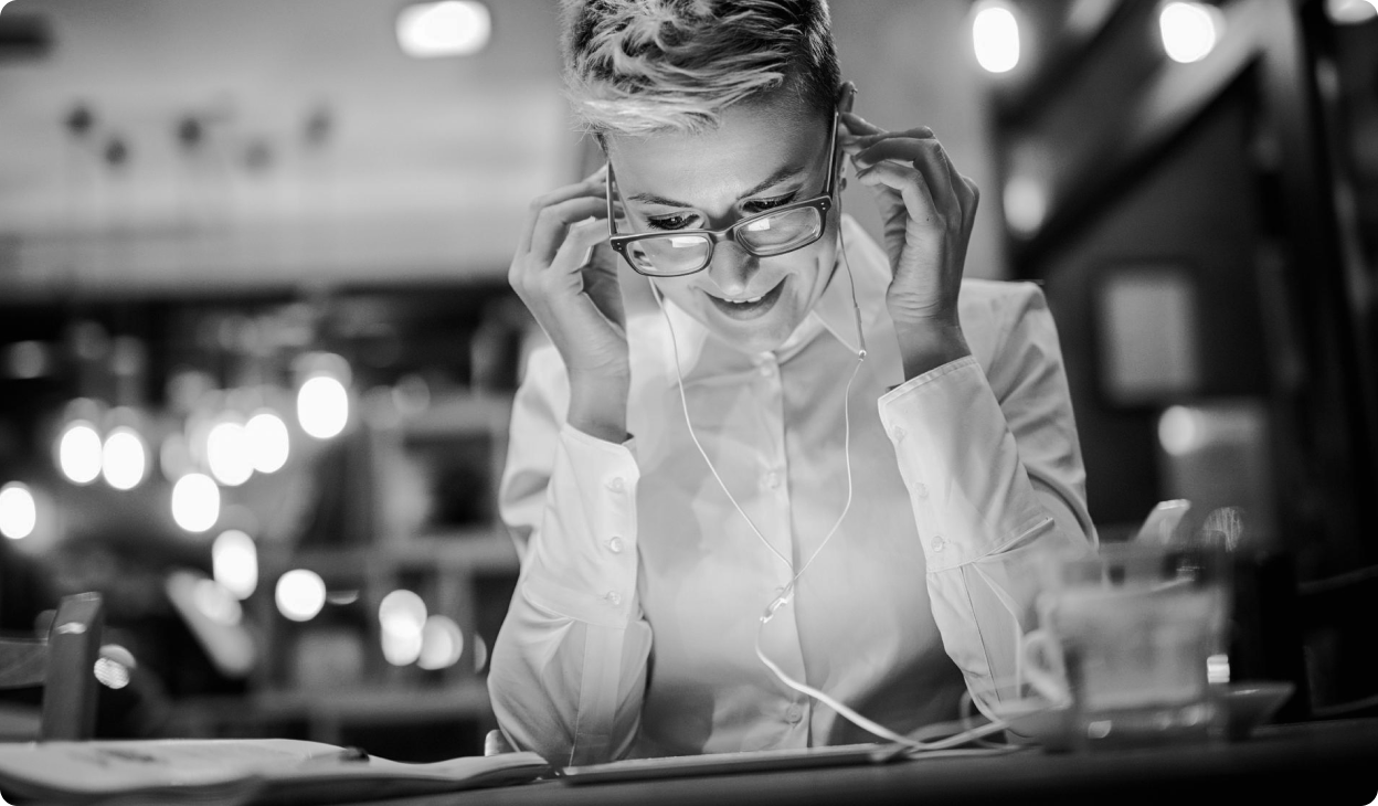 A person wearing glasses smiles in a restaurant