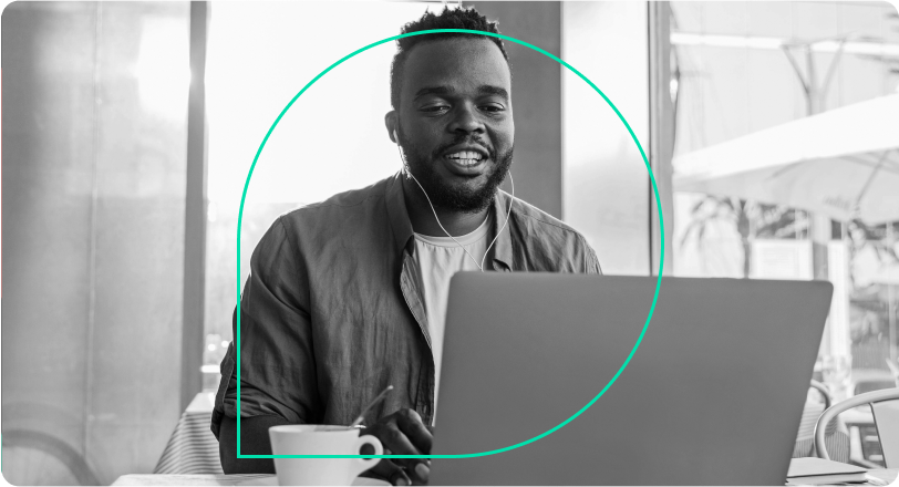 A person works on a laptop in an office behind Grammarly's logo.