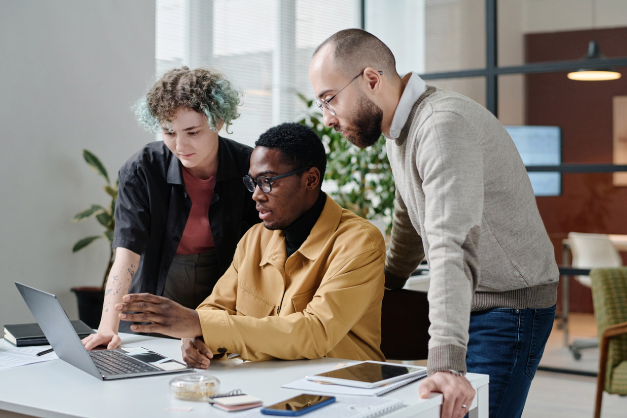 Three people looking at a computer together