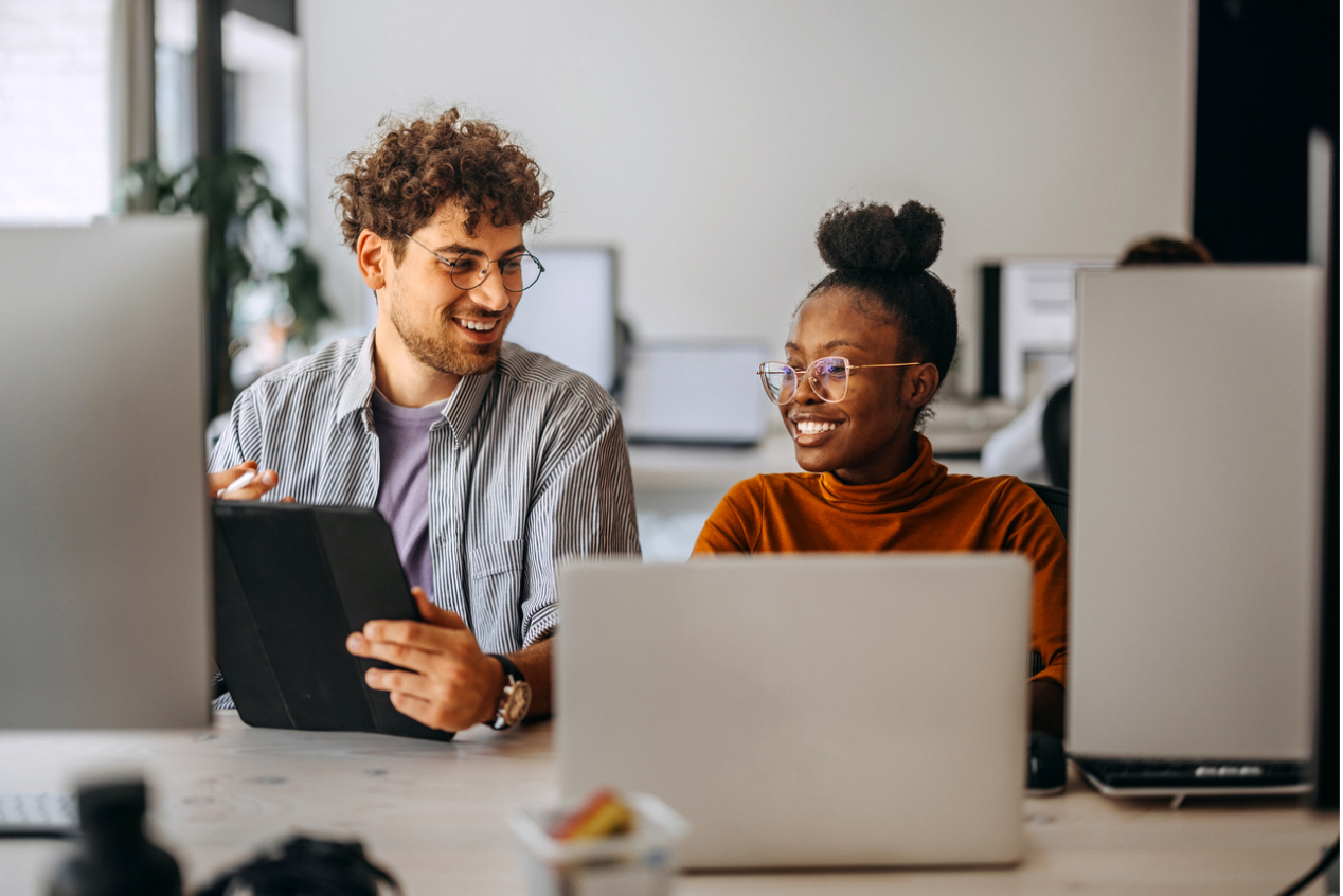 Two people with laptops laughing