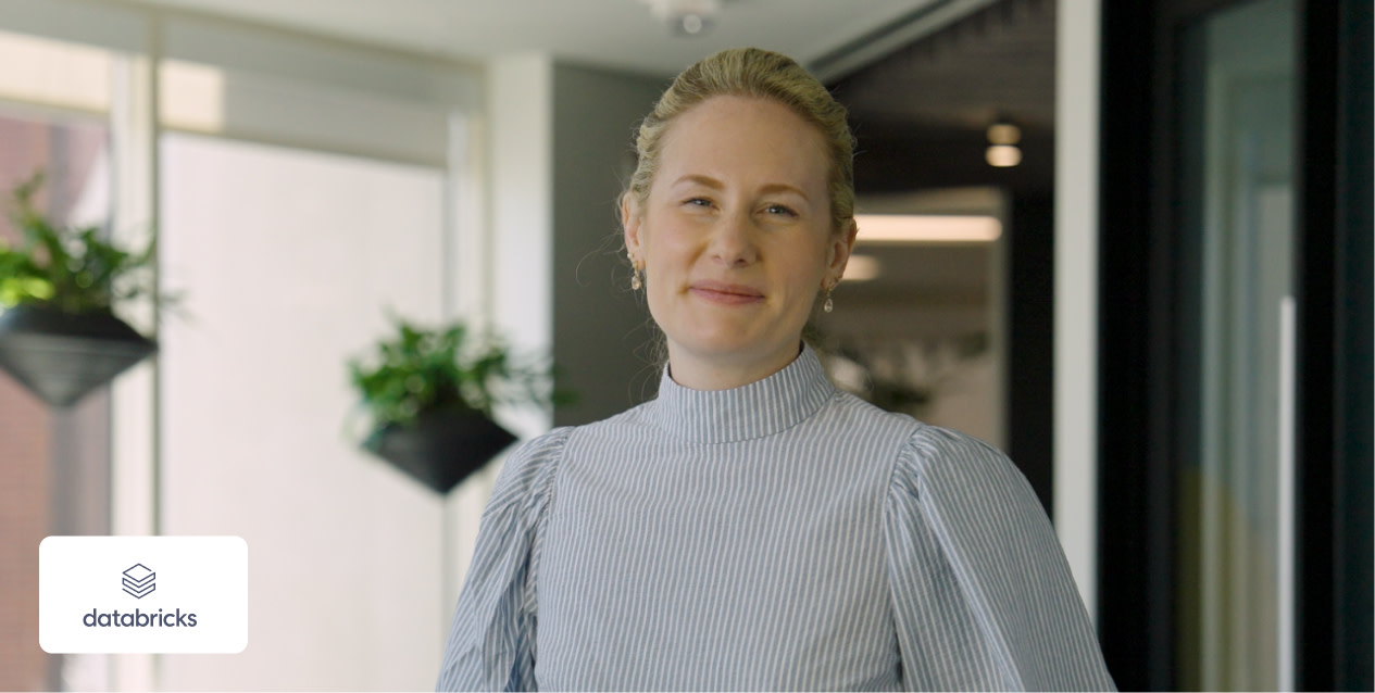 Woman standing behind the Databricks logo