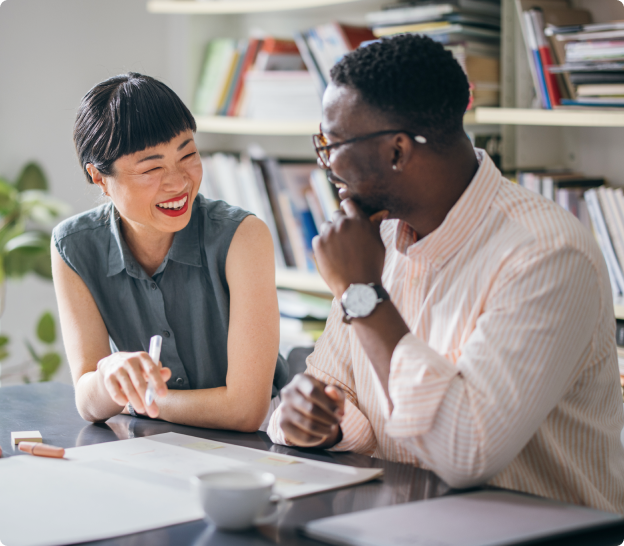 Two people talking with books behind them