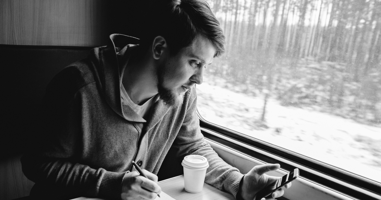 A person looks at their phone on a train