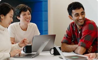 Group of people sitting at a table with laptops