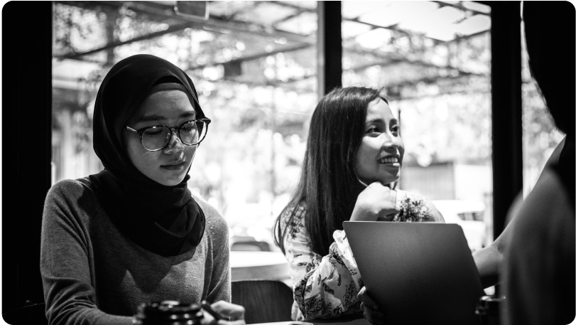 Two people sit at a desk 