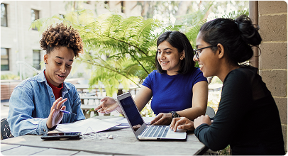 Image of students working together at a table outdoors