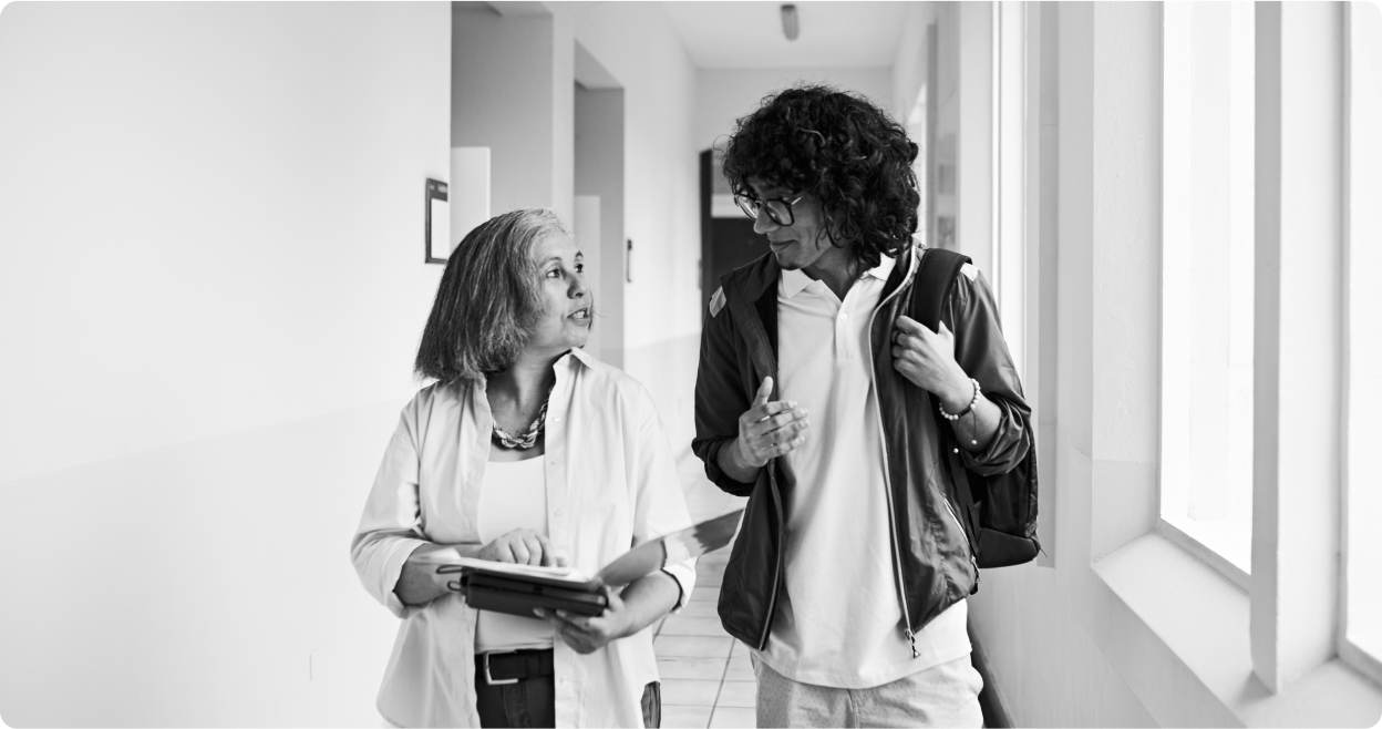 Student and teacher walking down a school hallway