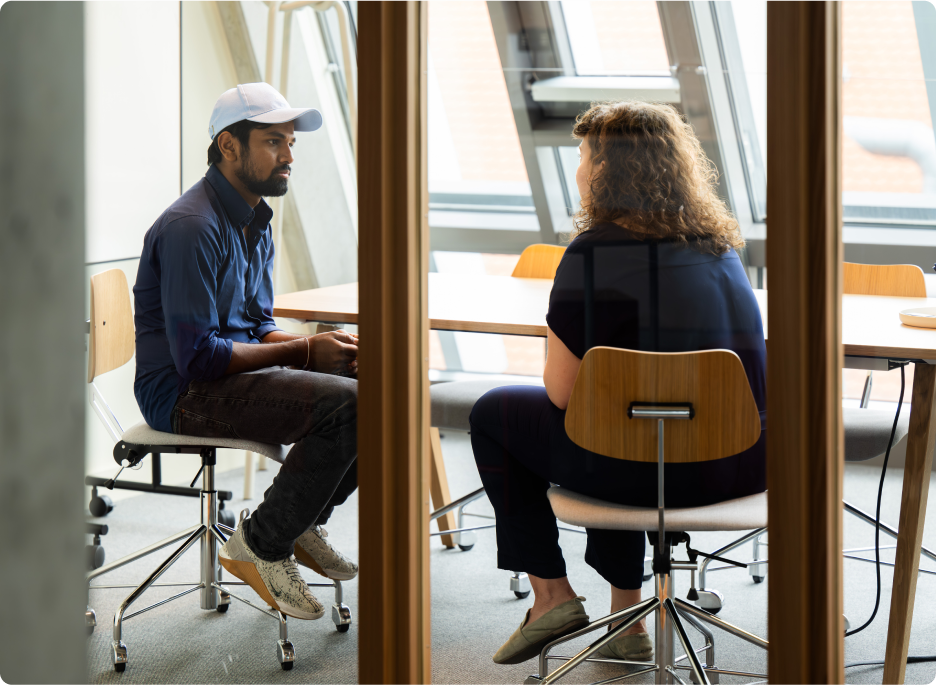 Colleagues sit around a desk chatting. 