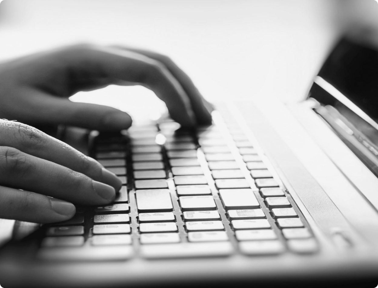 Hands typing on a laptop keyboard. 