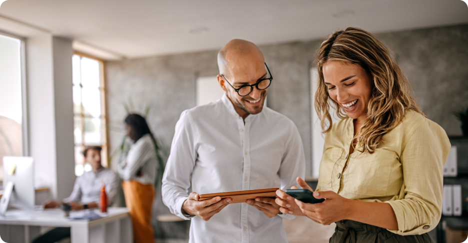 Two people smiling looking at a phone