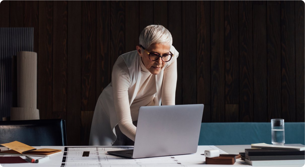 Person standing while looking at a laptop