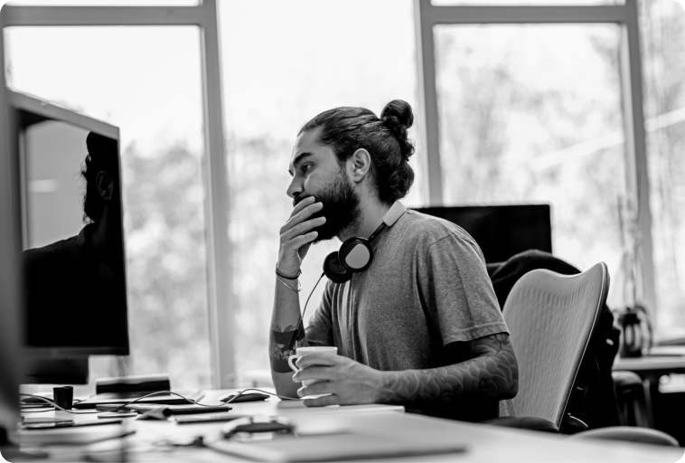 A person sits at a desk looking at a computer screen